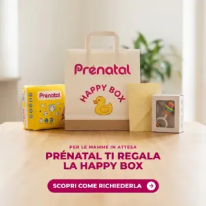 Happy Box Prénatal: la busta con pannolini, busta e sonaglio sul tavolo, cofanetto omaggio per le mamme in attesa